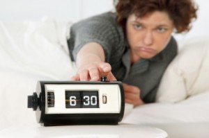 Woman hitting snooze alarm